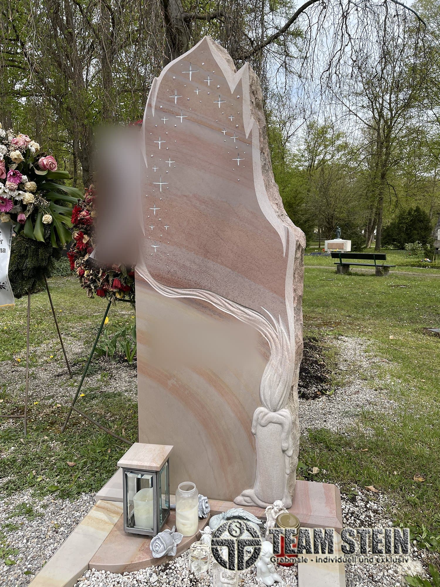 Hohe Sandstein-Stele mit Sternen und Kerzen-Relief