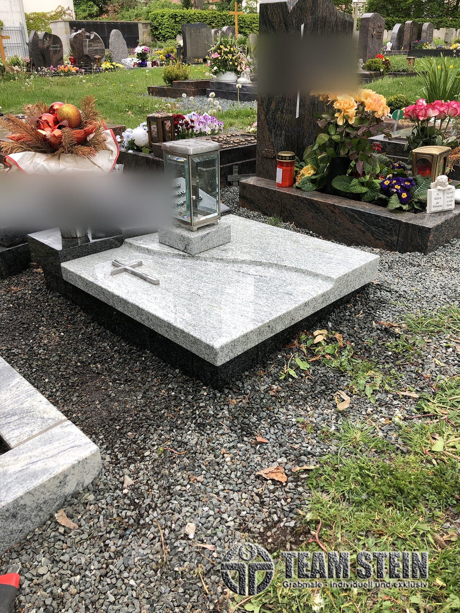 Helle Granit-Abdeckplatte mit Kreuz und Laterne auf dunklem Sockel